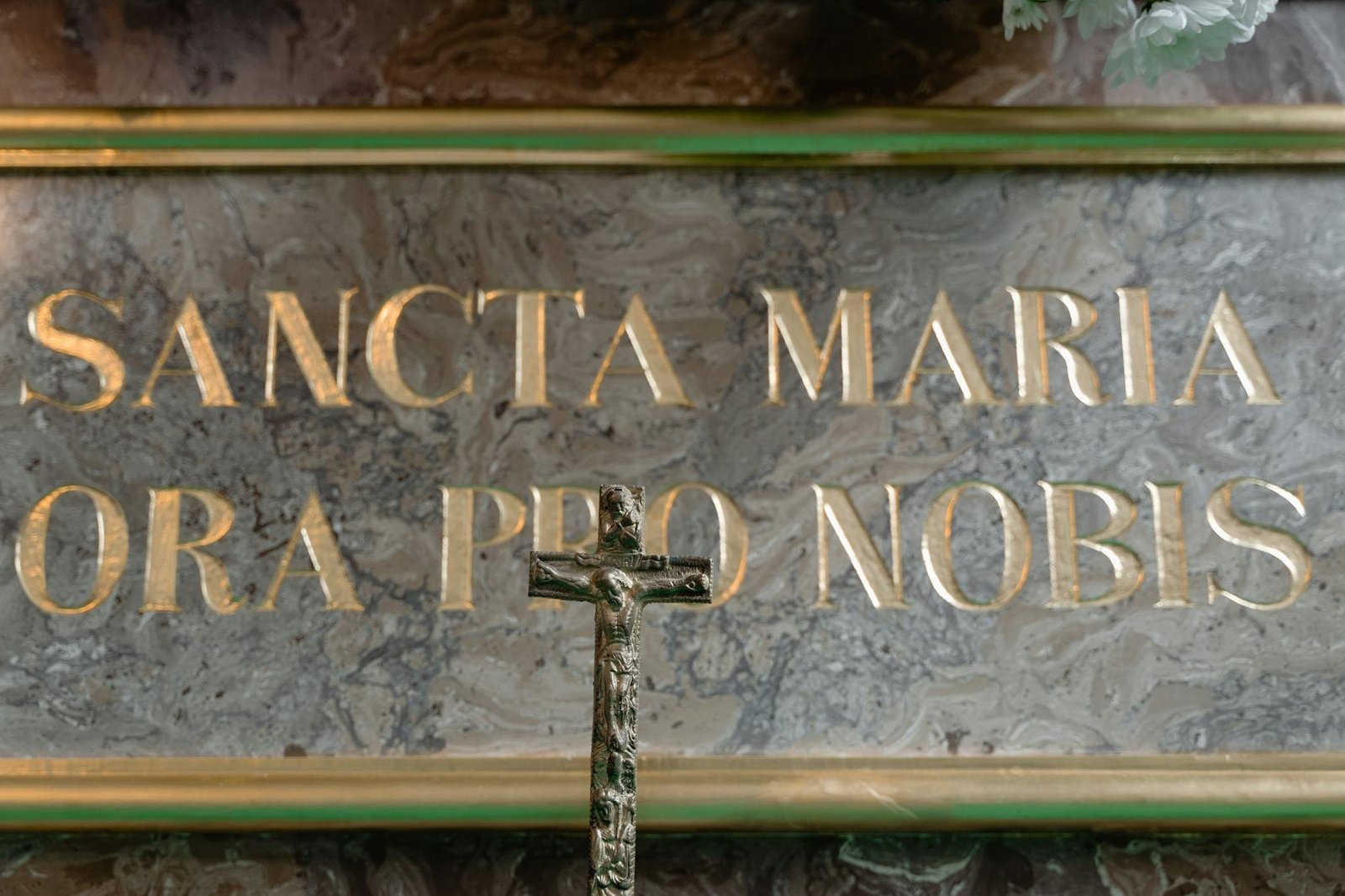 Crucifix before a marble inscription Sancta Maria Ora Pro Nobis